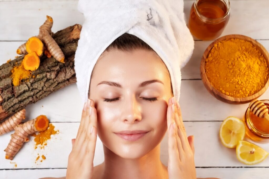 Turmeric powder and turmeric root on a wooden surface, symbolizing natural skincare benefits